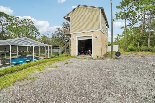 view of side of property featuring a fenced in pool, glass enclosure, and a balcony