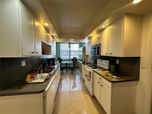 1501 S Ocean Dr Unit 201, Hollywood, FL 33019 - kitchen featuring white appliances, a sink, white cabinetry, dark countertops, and a tray ceiling