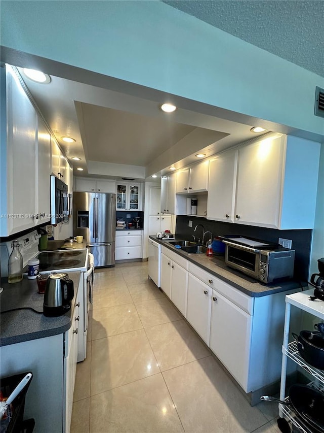 kitchen with white cabinets, white range with electric cooktop, sink, stainless steel refrigerator with ice dispenser, and light tile patterned floors