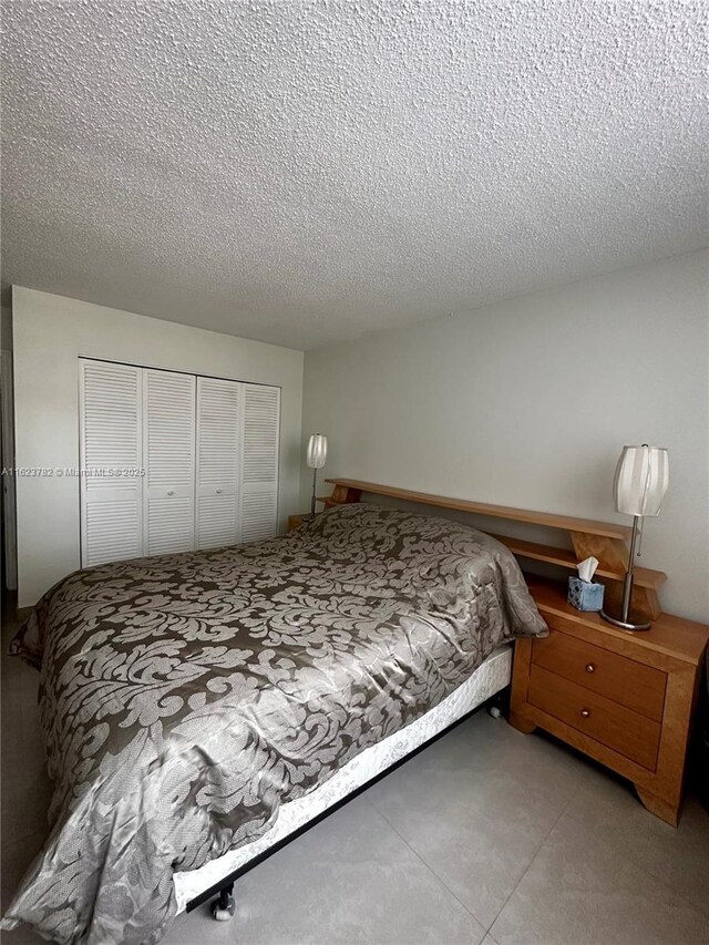 bedroom with a textured ceiling and a closet