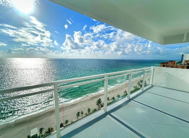 balcony featuring a water view and a view of the beach