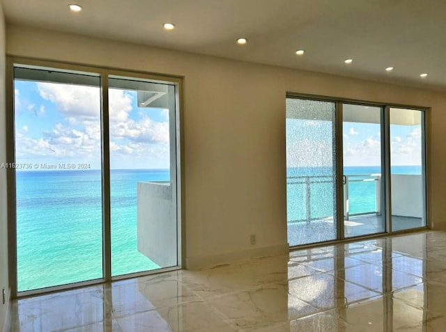 spare room with a water view and plenty of natural light