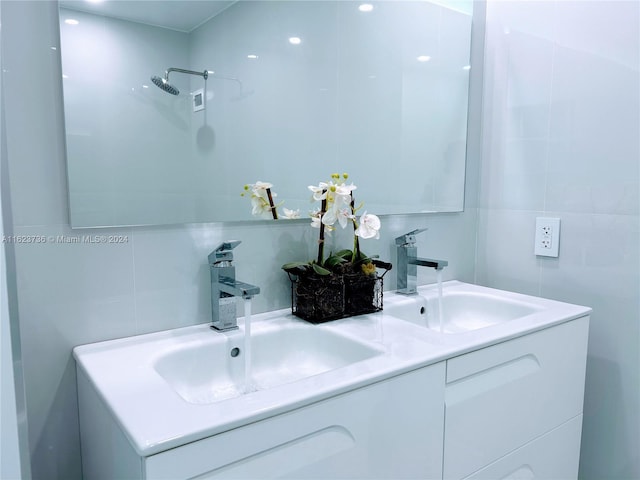 bathroom featuring tile walls, vanity, a shower, and backsplash