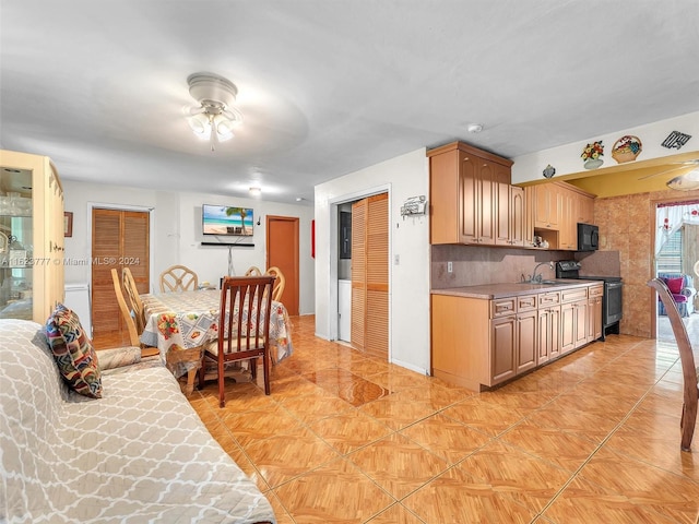 kitchen with ceiling fan, sink, tasteful backsplash, and black appliances