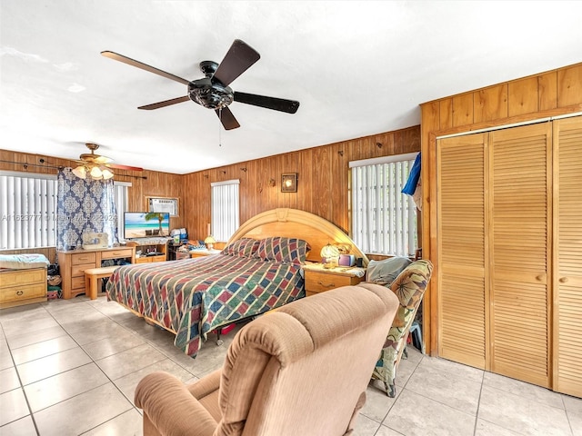 bedroom with multiple windows, ceiling fan, and wooden walls