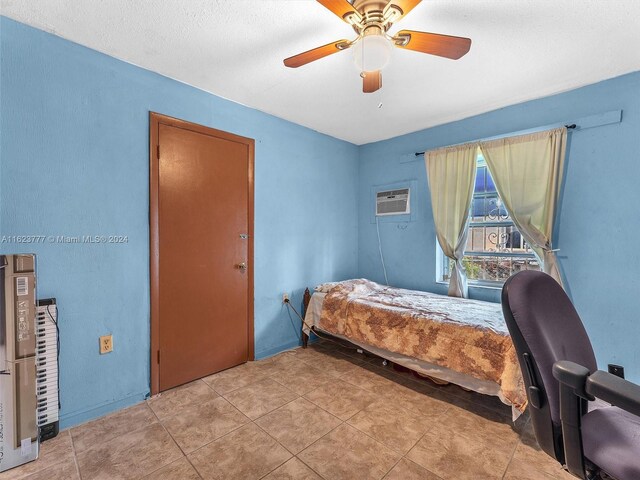 tiled bedroom featuring a wall mounted AC and ceiling fan