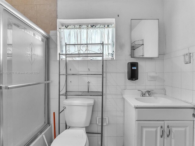 bathroom featuring tile walls, toilet, and vanity