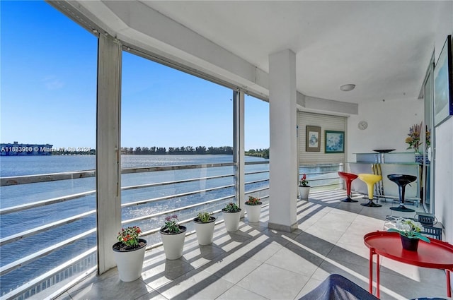 sunroom / solarium featuring a water view