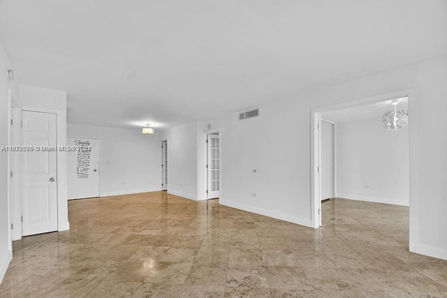 unfurnished room featuring a notable chandelier