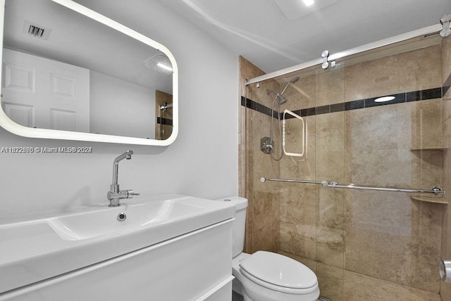 bathroom featuring a tile shower, vanity, and toilet