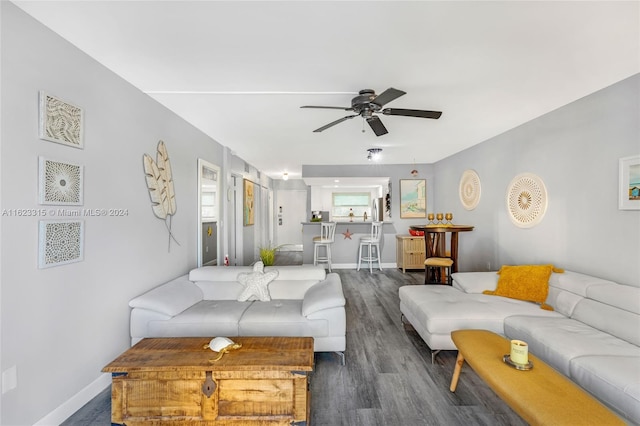 living room with dark wood-type flooring and ceiling fan