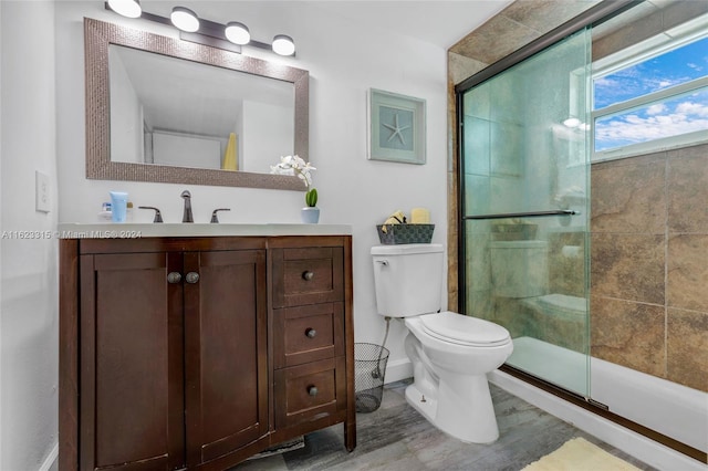 bathroom featuring vanity, an enclosed shower, and toilet