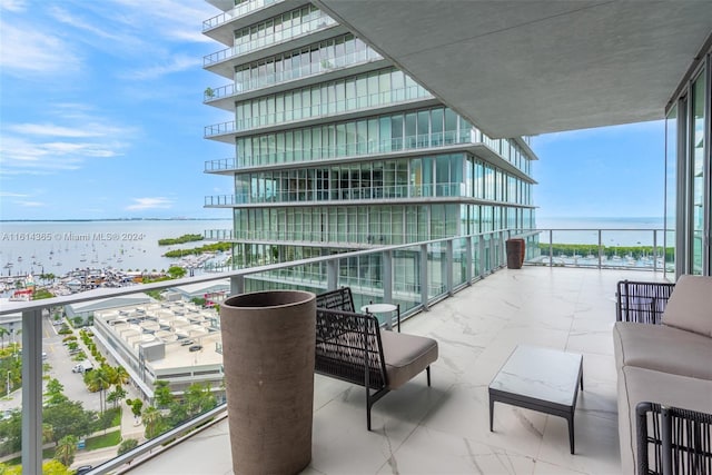 balcony with an outdoor living space and a water view