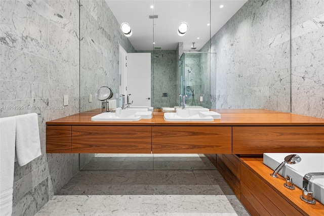 bathroom with an enclosed shower, vanity, and tile walls