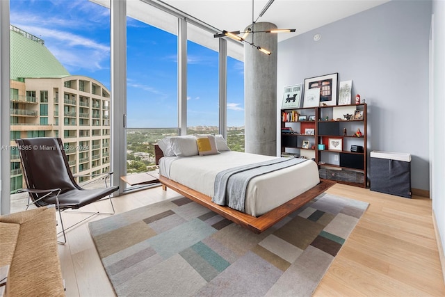 bedroom with light hardwood / wood-style floors, expansive windows, and multiple windows