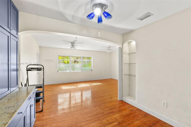 1310 15th St, Miami Beach, FL 33139 - empty room featuring a ceiling fan, arched walkways, light wood-style flooring, and baseboards