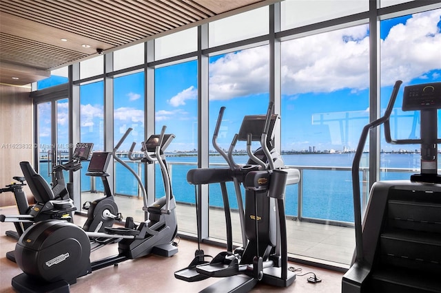 gym with expansive windows and a water view