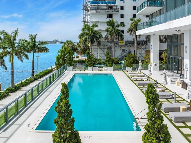 view of pool with a patio and a water view