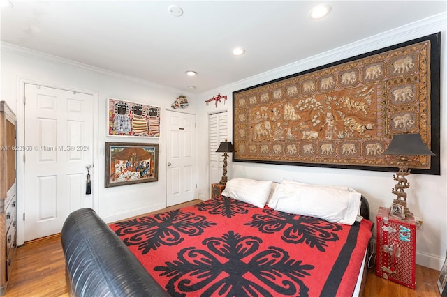 bedroom featuring light hardwood / wood-style flooring, ornamental molding, multiple windows, and access to outside