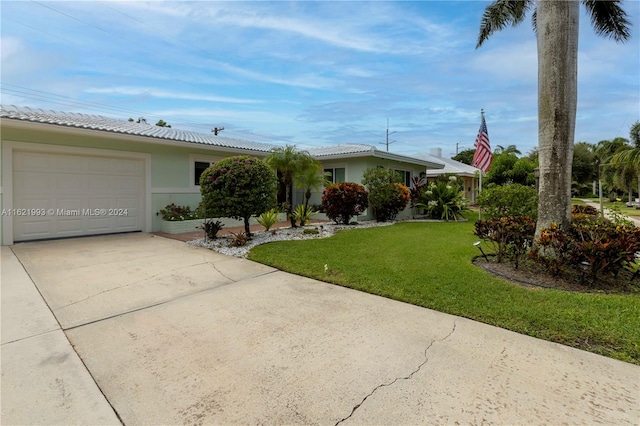 ranch-style home featuring a garage and a front lawn