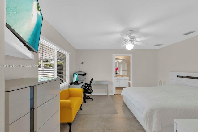 bedroom with ensuite bathroom, light tile patterned floors, and ceiling fan