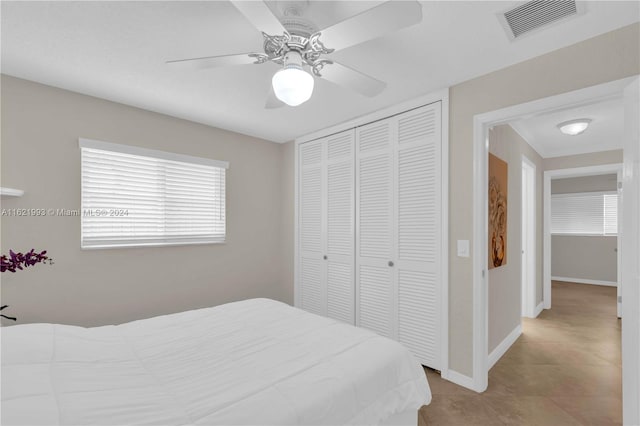 tiled bedroom featuring ceiling fan and a closet