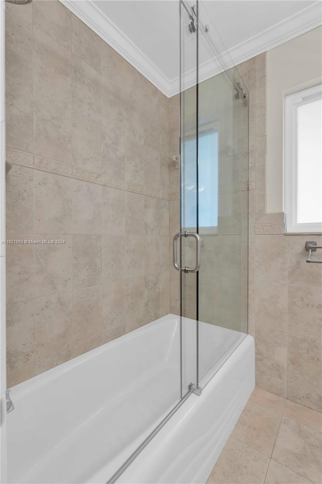 bathroom featuring tile patterned flooring, tile walls, bath / shower combo with glass door, and crown molding