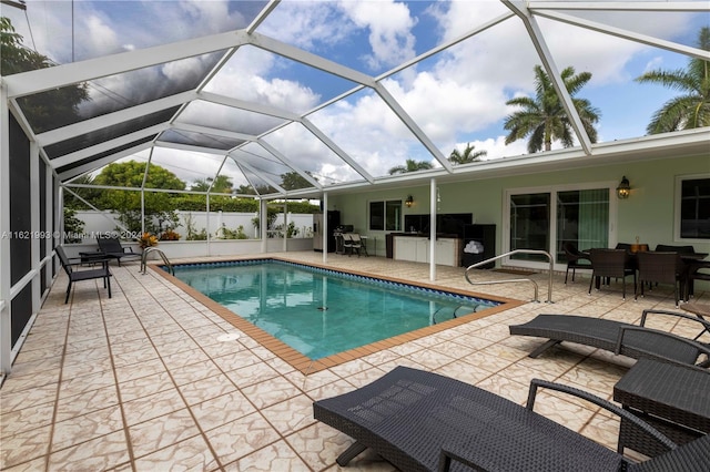 view of swimming pool with glass enclosure and a patio area