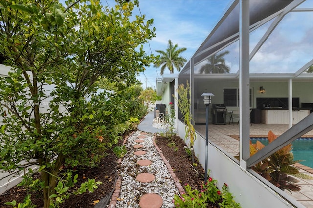 view of yard featuring glass enclosure and a patio area