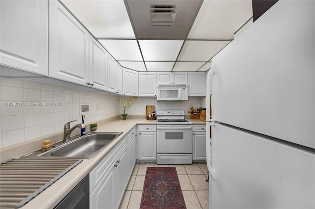 kitchen featuring white appliances, light tile patterned floors, white cabinets, decorative backsplash, and sink