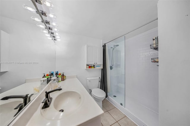 bathroom with vanity, a shower with shower door, toilet, and tile patterned flooring