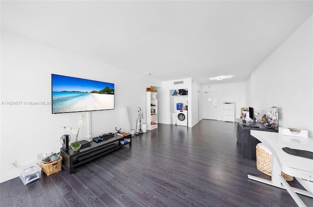 living room with dark hardwood / wood-style floors and washer / dryer