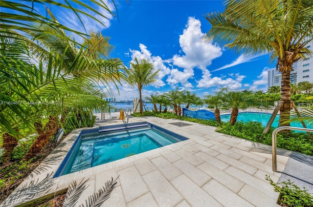 view of swimming pool with a community hot tub and a patio area