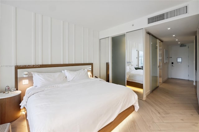 bedroom with light parquet floors and a closet