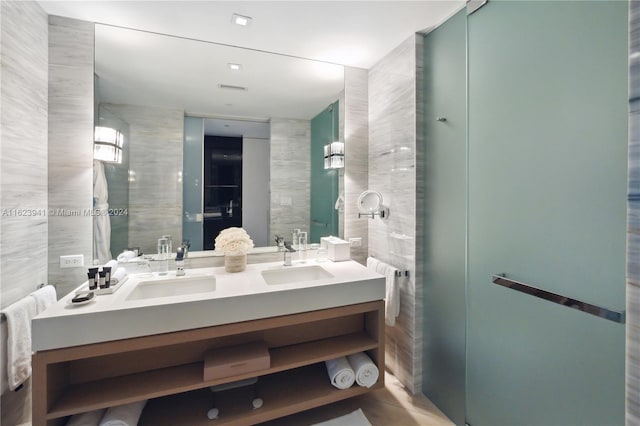 bathroom with double sink vanity and tile walls