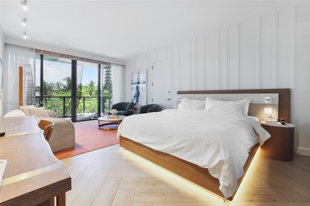 bedroom featuring light parquet flooring and access to exterior