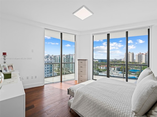 bedroom featuring access to exterior, a wall of windows, and dark hardwood / wood-style flooring