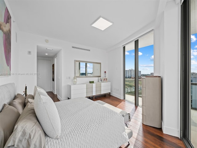 bedroom featuring access to exterior, floor to ceiling windows, and dark hardwood / wood-style floors