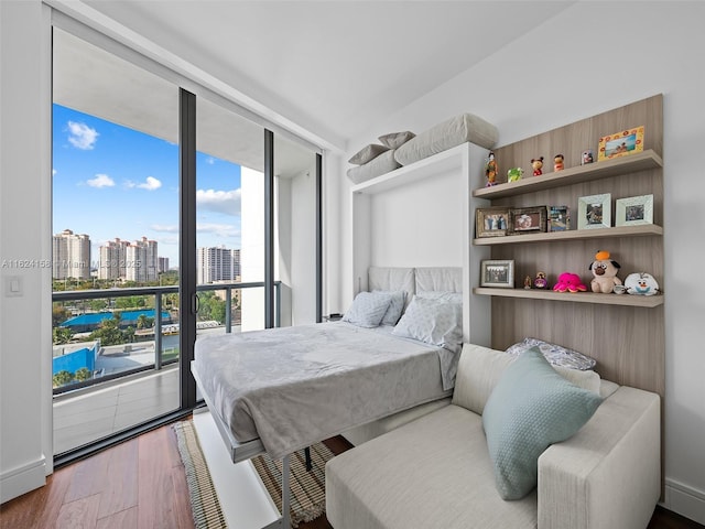 bedroom featuring hardwood / wood-style floors and expansive windows