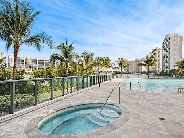 view of swimming pool featuring a patio area and a hot tub