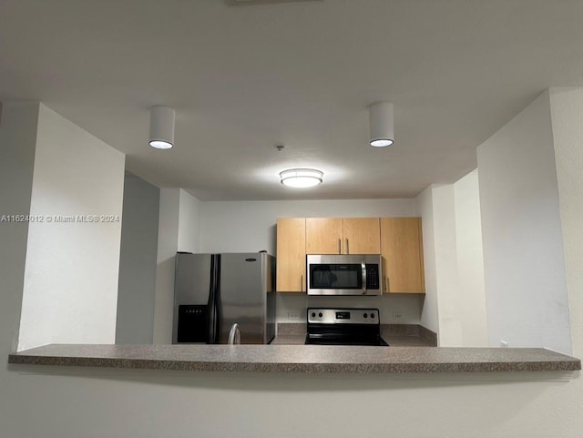 kitchen with light brown cabinets and stainless steel appliances