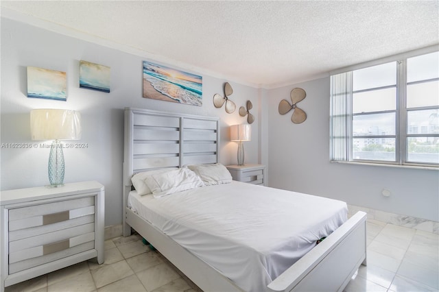 bedroom featuring light tile patterned flooring and a textured ceiling