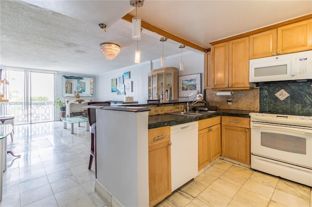 kitchen featuring white appliances, a textured ceiling, kitchen peninsula, decorative light fixtures, and sink