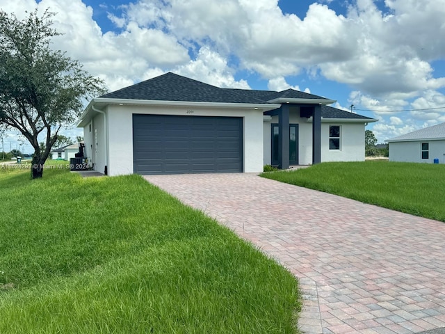 view of front of property with a garage and a front lawn