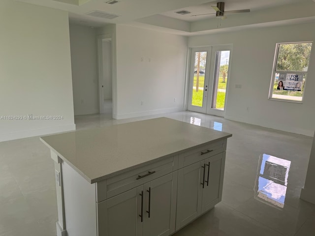 kitchen featuring a center island, ceiling fan, and light tile patterned floors