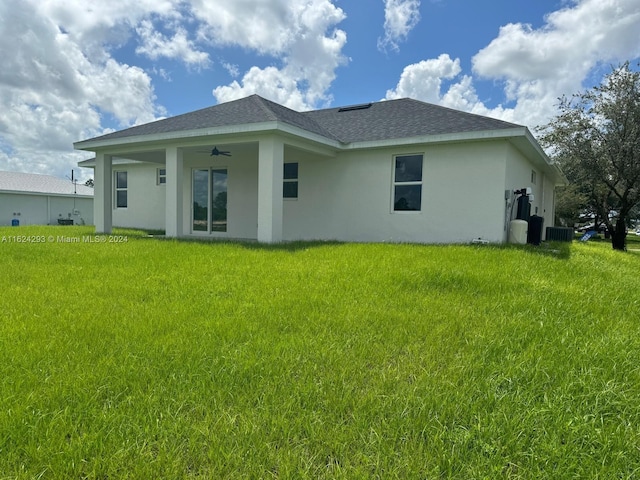 back of house featuring a yard and ceiling fan