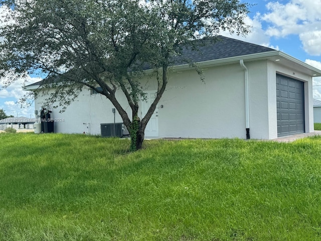 view of side of home with a yard, a garage, and cooling unit