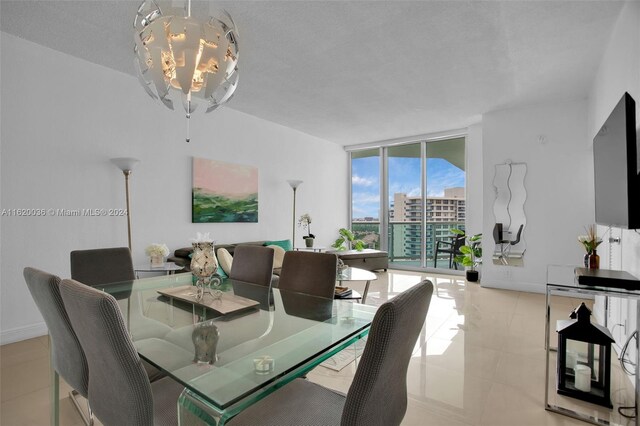 dining area featuring a chandelier, a wall of windows, light tile patterned floors, and a textured ceiling