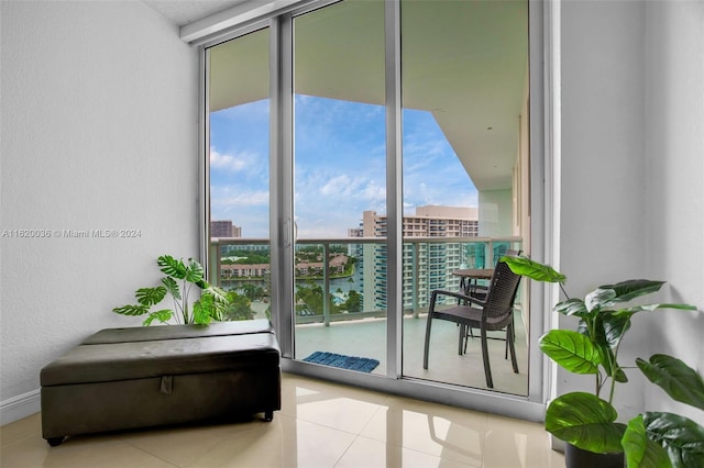 doorway to outside featuring expansive windows, light tile patterned flooring, and a water view