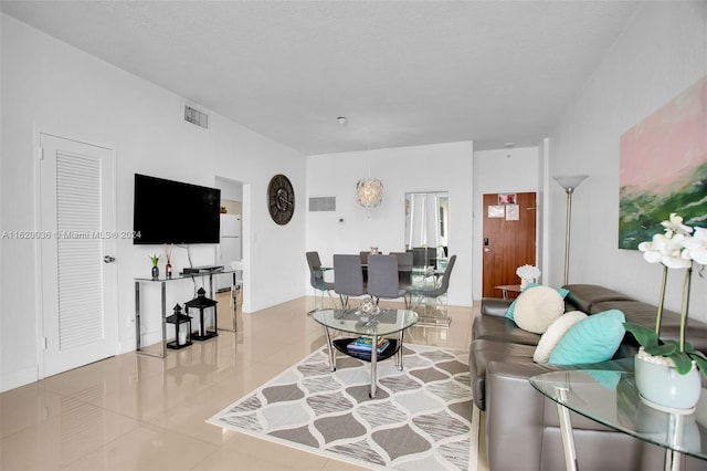 tiled living room featuring a textured ceiling